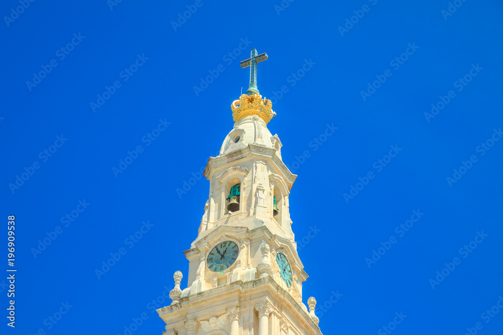 Bell tower of Sanctuary of Our Lady of Fatima in blue sky. Basilica of Nossa Senhora is one of the most important shrines of the world dedicated to Virgin Mary and biggest pilgrimage Site in Portugal.