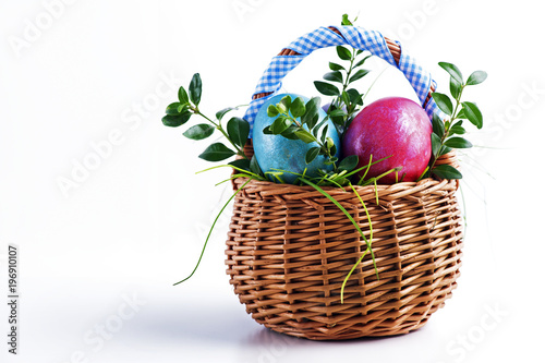 Colorful Easter eggs in a small Easter basket on a white background