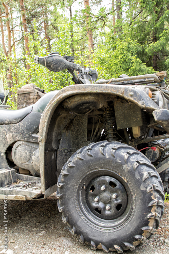 The modern quad bike parked at the forest in summer day