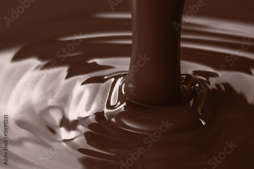 Pouring liquid hot chocolate closeup. Cooking dessert.