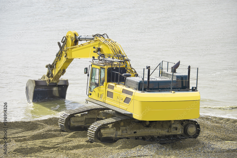 Construction Site - Engineering - Sea Defence. Large plant machinery being use to build the beach sea defence at Seaford, East Sussex, UK