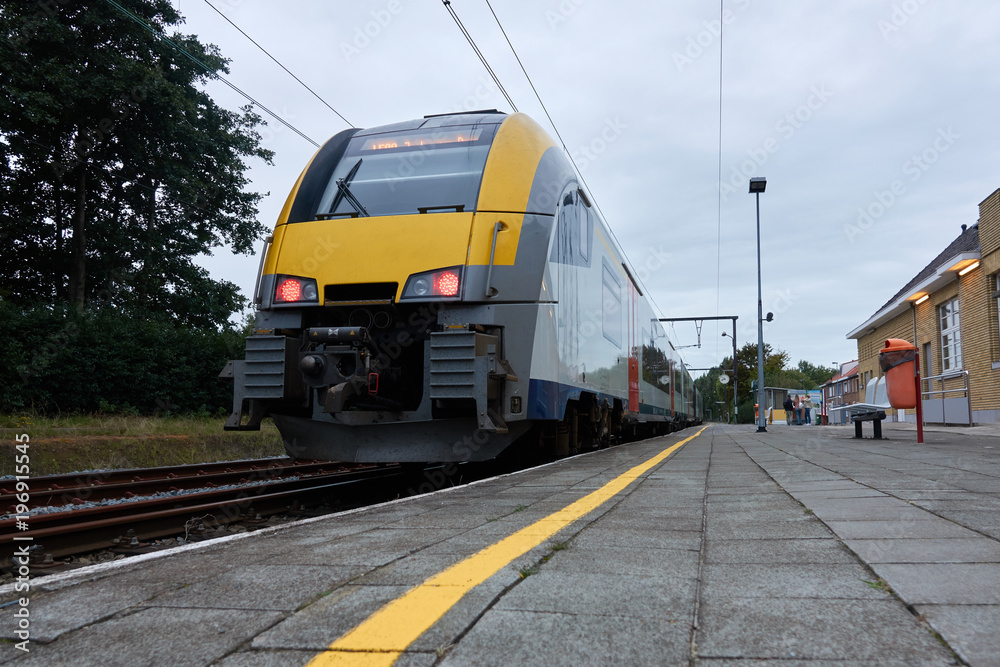 Railway station with yellow train at the platform Railway station with yellow train at the platform
