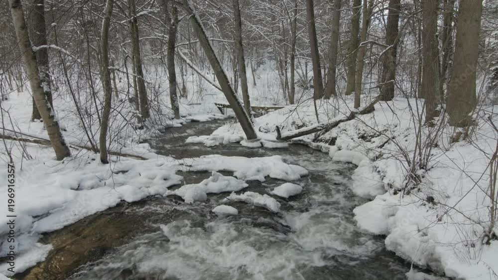 Small creek in winter snowy forest among snow banks. Lithuania. Small creek in winter snowy forest among snow banks. Lithuania.