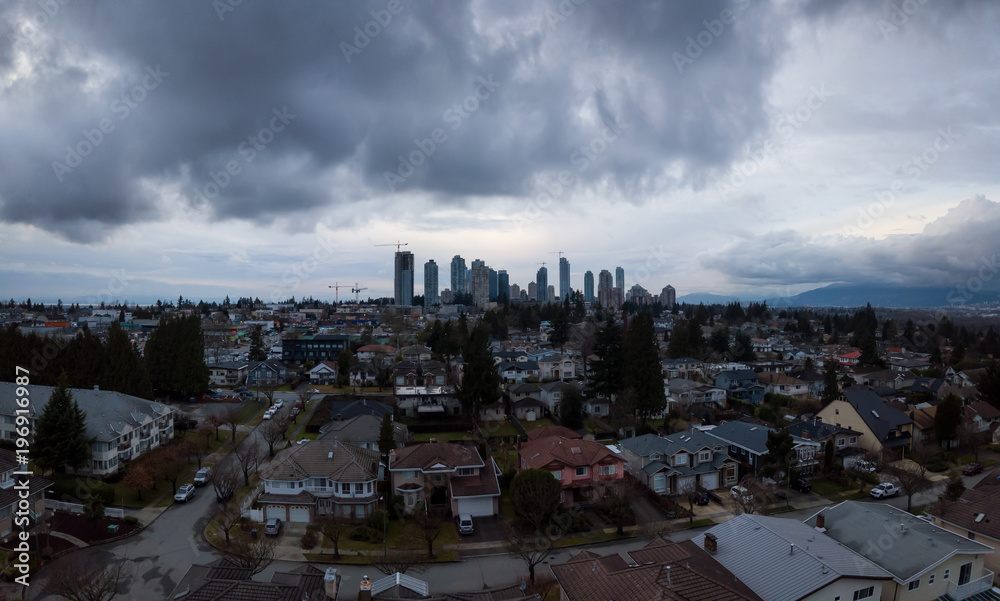 Aerial panoramic view of Residential Homes during a cloudy sunset. Taken in Burnaby, Greater Vancouver, British Columbia, Canada.
