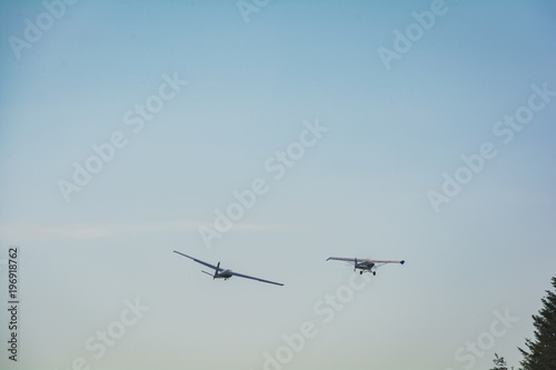 Glider and Tow plane in action on a green airfield 