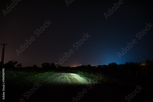Starry road with blue and red lights in the night sky photo
