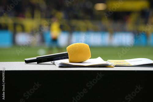 Foto Gelbes Mikrofon auf TV Moderationspult im Stadion