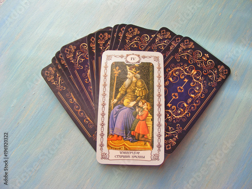 Tarot cards medieval close up with russian title The Emperor Tarot Decks on blue wooden background photo