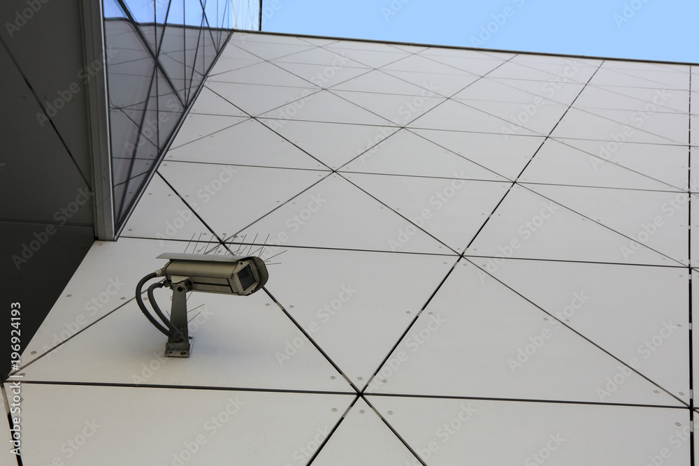 Kamera monitoringu na ścianie współczenego budynku, wierzowca. - obrazy, fototapety, plakaty 