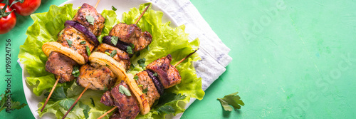 Grilled shish kebab or shashlik on green table.