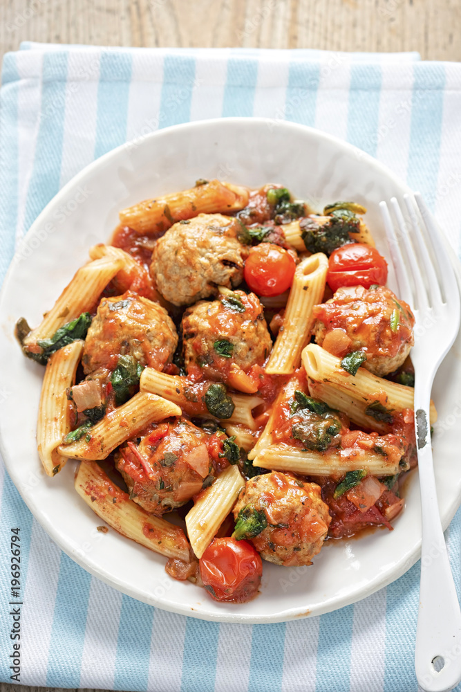 Pork meatballs with pasta, cherry tomatoes, spinach in tomato sauce Pork meatballs with pasta, cherry tomatoes, spinach in tomato sauce