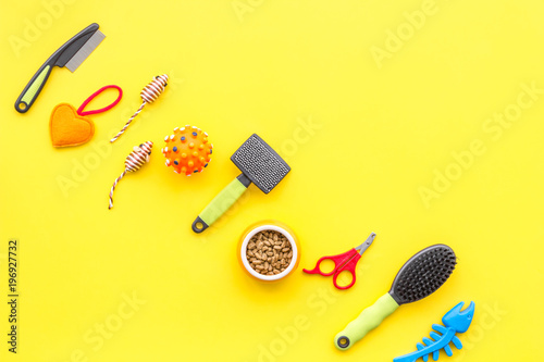 Acessories for the grooming of the dog. Combs and brushes for dogs. Yellow background top view mock-up photo