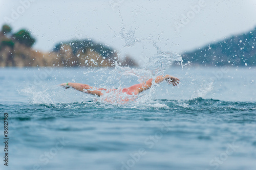 young sporting man swims in the sea dolphin style. © dima