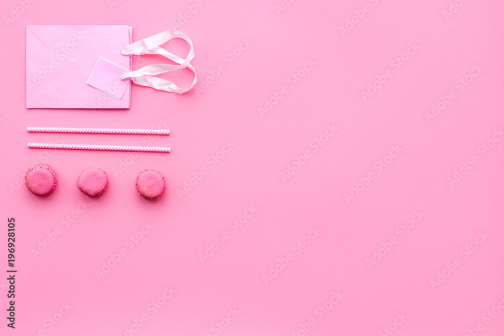 Gift concept. Sweets, paper bag for gift on pink background top view copy space