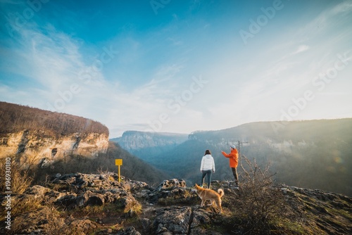 man and girl with their dog on mountain