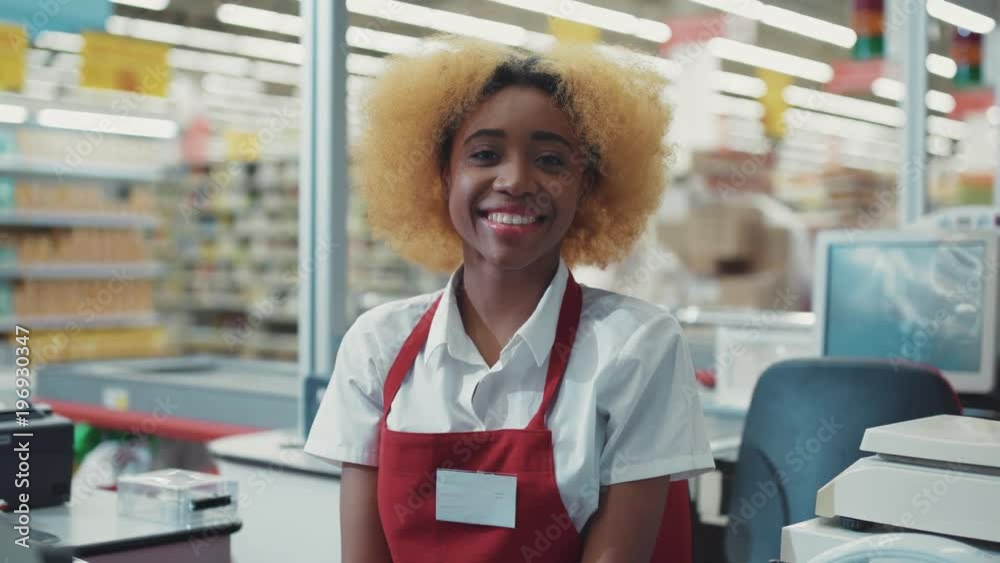 Portrait african american woman blond hair works at supermarket cash desk look camera smiling happy girl fruit technology grocery market store black retail indoors consumer vegetables slow motion