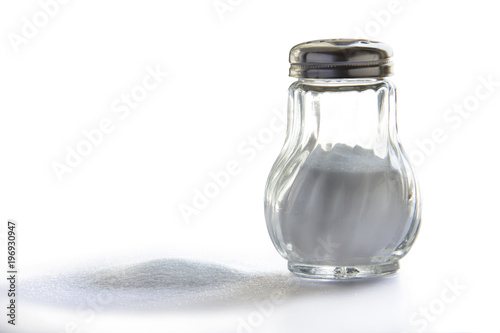 Salero de vidrio con tapa metálica sobre fondo blanco