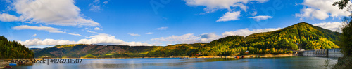 Panorama view over Izvorul Muntelui lake and dam with autumn scenery and beautiful blue sky
