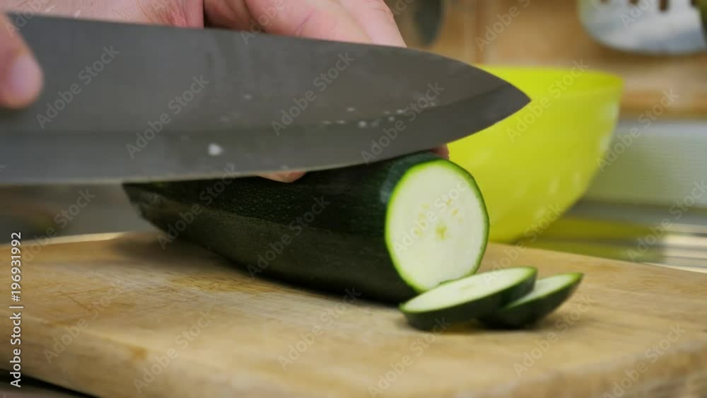 Man cutting zucchini vegetables with kitchen knife