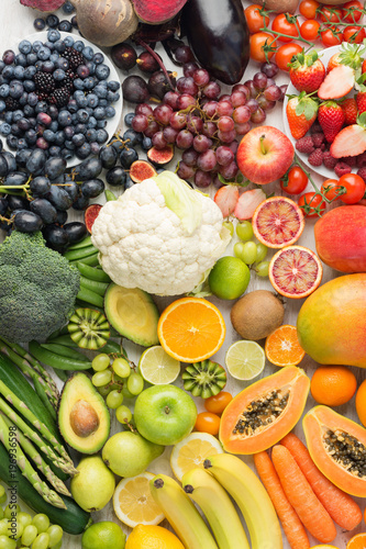 Fototapeta Naklejka Na Ścianę i Meble -  Healthy eating background, assortment of different fruits and vegetables in rainbow colours on the off white table arranged in a rectangle, top view, selective focus