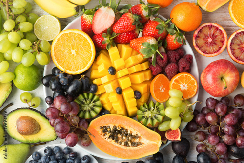 Healthy food background  assortment of fruits in rainbow colours on the off white table  top view  selective focus