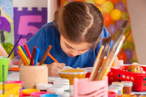 Small students painting in art school class. Child drawing by paints on table. Boy and girls in kindergarten. Drawing education develops creative abilities of children. Hobby for teenagers.