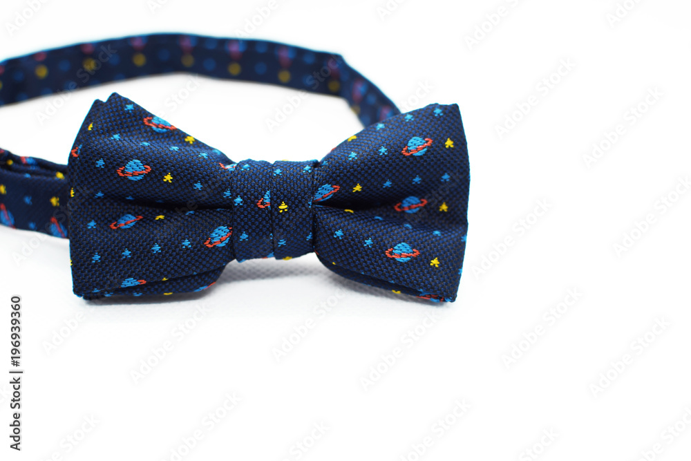 Beautiful colorful blue bow tie with light blue planets and yellow stars on white background with space for text. Beautiful colorful blue bow tie with light blue planets and yellow stars on white background with space for text.