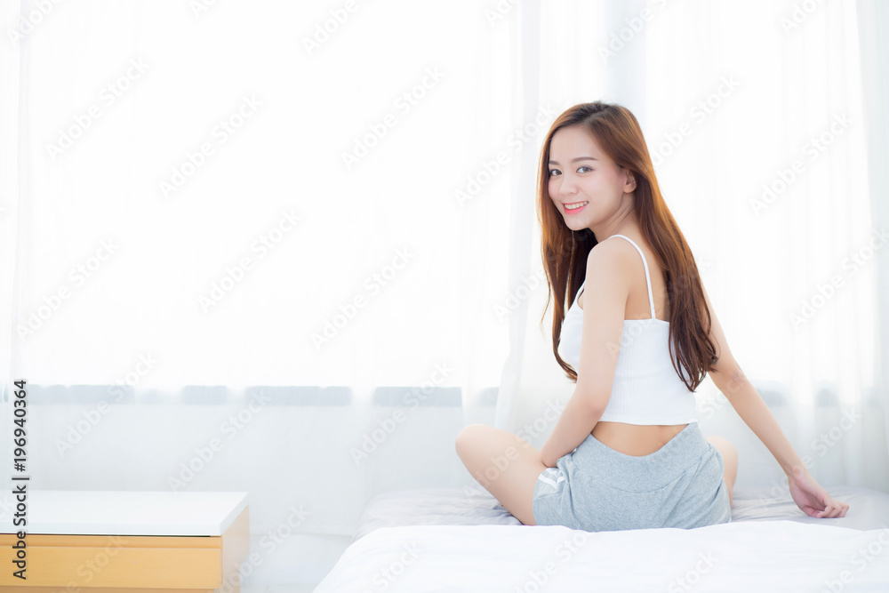 Beautiful asian young woman smiling with happiness leisure sitting on bed at home by the window, girl relax and wellness concept. Beautiful asian young woman smiling with happiness leisure sitting on bed at home by the window, girl relax and wellness concept.