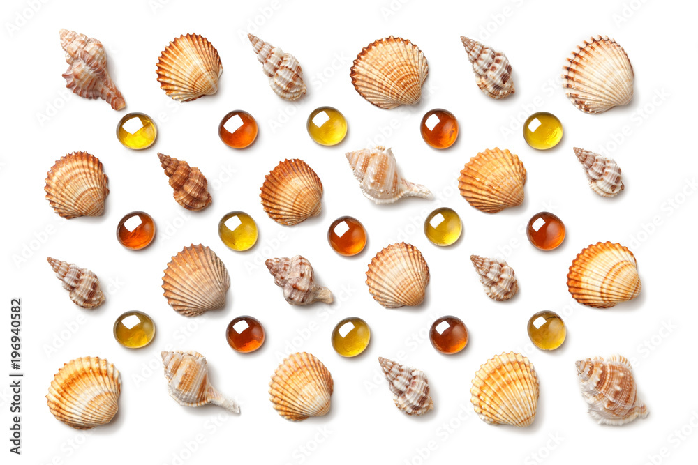Pattern made of shells and orange glass beads isolated on white background Pattern made of shells and orange glass beads isolated on white background