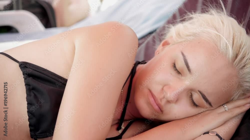 Beautiful woman in bikini sunbathing at the seaside woman blonde young sleep on beach Beautiful woman in bikini sunbathing at the seaside woman blonde young sleep on beach
