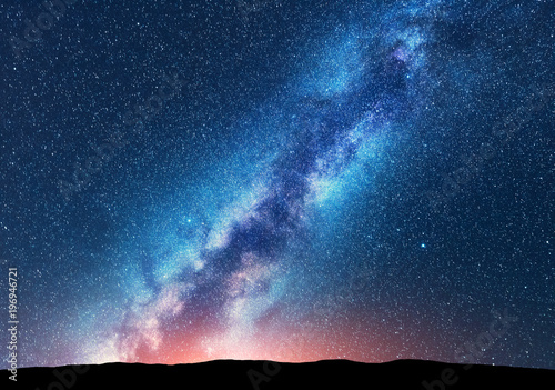 Milky Way. Space. Scenic night landscape with bright milky way, sky full of stars, orange light and hills. Shiny stars. Beautiful scene with universe. Space background with starry sky. Concept. Nature