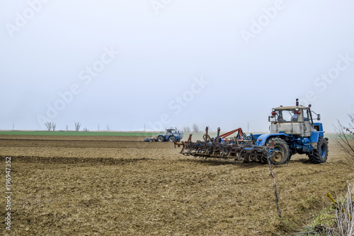 Lush and loosen the soil on the field before sowing. The tractor plows a field with a plow