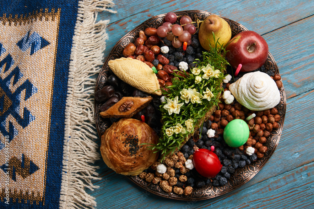 Novruz tray plate with Azerbaijan national pastry pakhlava , shekerbura, gogal and dry fruit snack on rustic table  background. spring new year celebration top view