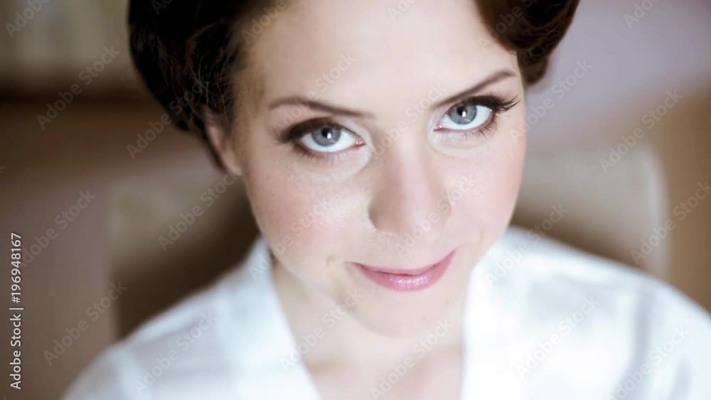 Beauty bride in dressing gown with bridal makeup indoors Beauty bride in dressing gown with bridal makeup indoors