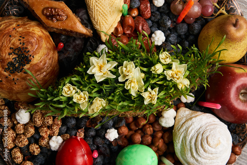 Novruz tray plate with Azerbaijan national pastry pakhlava , shekerbura, gogal and dry fruit snack on rustic table  background. spring new year celebration top view