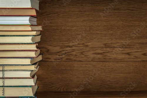 old books on a wooden shelf. stacked one on top of another. background.