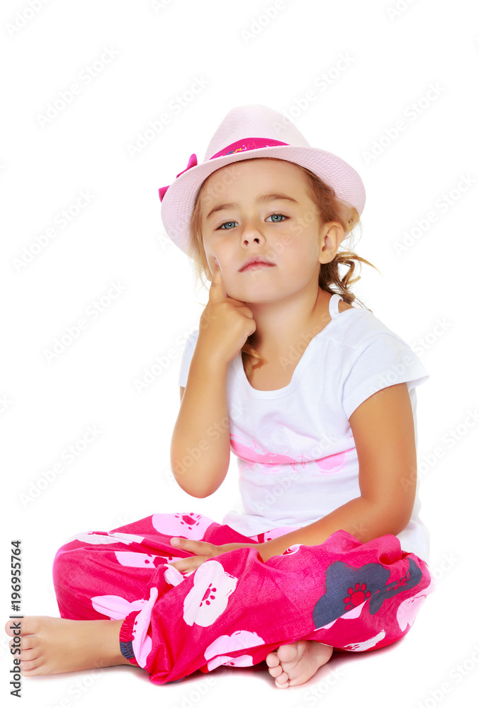 Little girl is sitting on the floor.