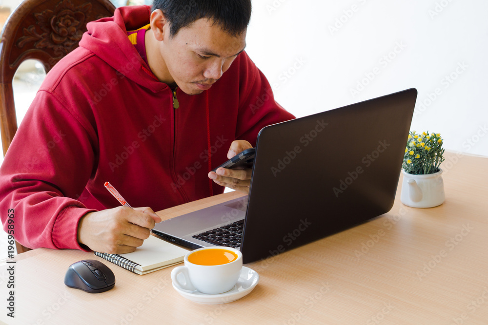 The man put the red pen and writing on the small notebook. The man put the red pen and writing on the small notebook.