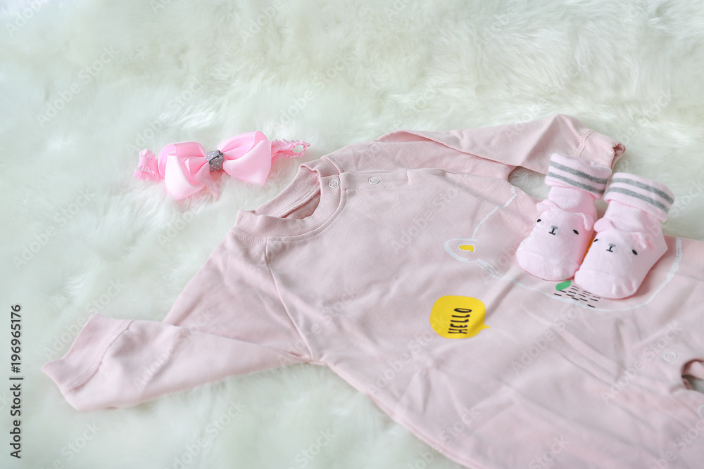 bodysuits for newborn babies with socks on white fur background. bodysuits for newborn babies with socks on white fur background.