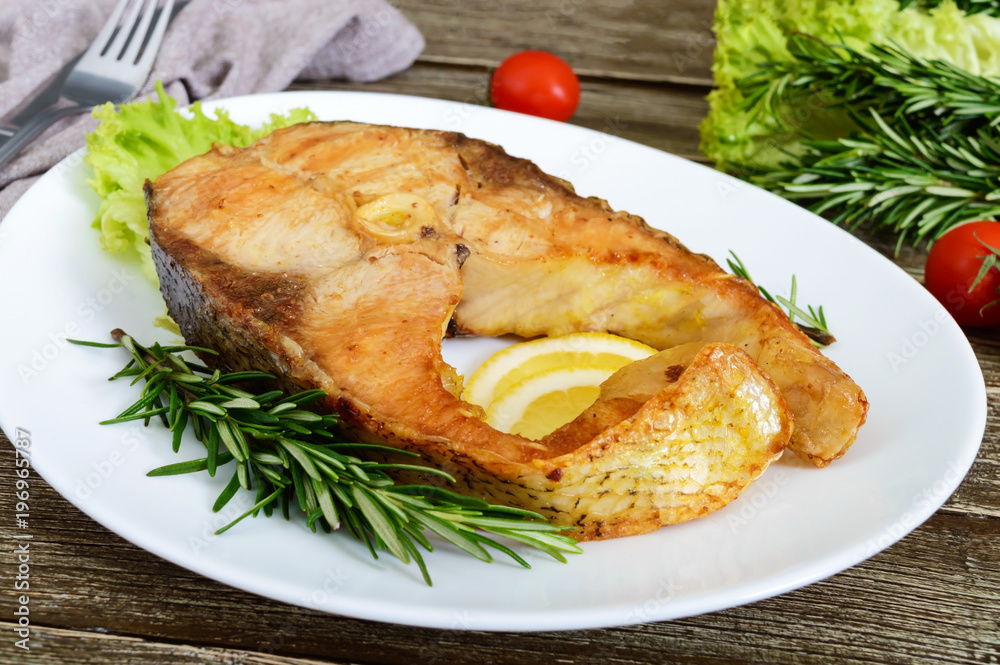 Big roasted carp steak with lemon and rosemary. Big roasted carp steak with lemon and rosemary.
