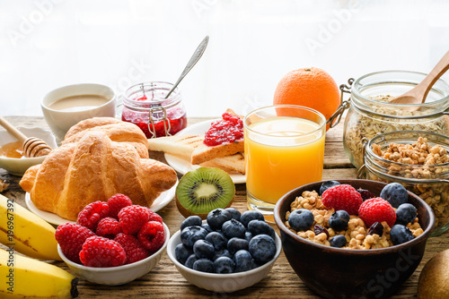 Breakfast served with coffee, orange juice, toasts, croissants, cereals, milk, nuts and fruits