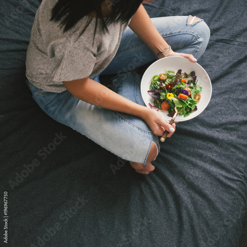 Young woman eating salad on bed home © kucherav