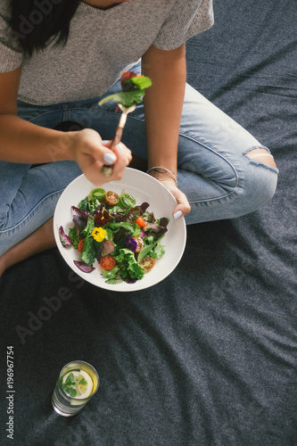 Top view young woman eating salad sitting bed home © kucherav