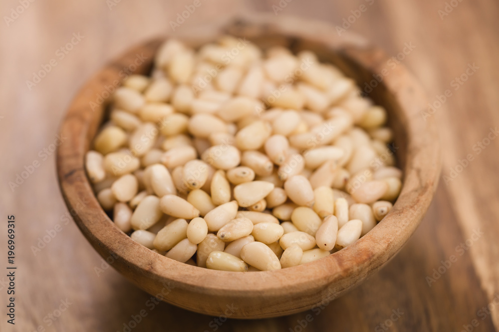 pine nuts in wood bowl on table pine nuts in wood bowl on table