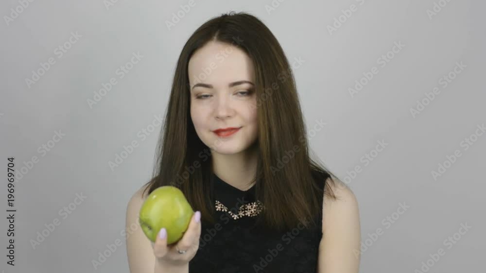 Beautiful young woman eats a green apple. Concept of eating fresh fruits vegetarian Beautiful young woman eats a green apple. Concept of eating fresh fruits vegetarian
