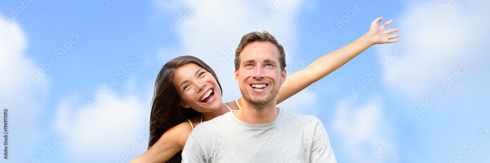 Happy young couple freedom screaming of joy on blue sky summer background panoramic banner. Portrait of two interracial people tourists outside. Happy young couple freedom screaming of joy on blue sky summer background panoramic banner. Portrait of two interracial people tourists outside.