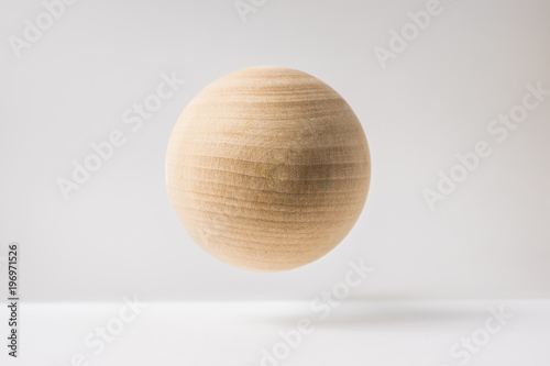 Design concept - abstract real wooden sphere with surreal layout on white surface background and it s not 3D render