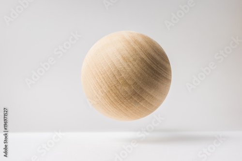 Design concept - abstract real wooden sphere with surreal layout on white surface background and it's not 3D render