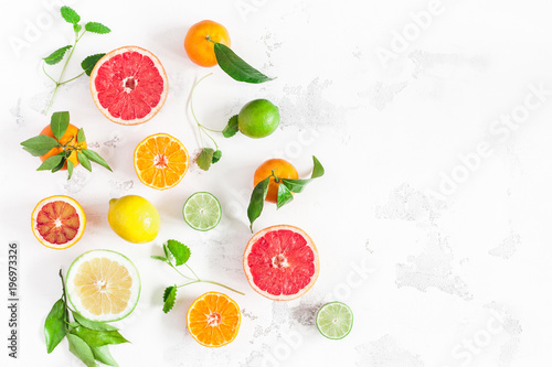 Fruit background. Colorful fresh fruits on white table. Orange, tangerine, lime, lemon, grapefruit. Flat lay, top view, copy space