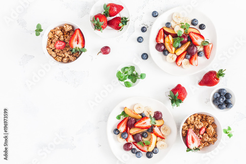 Fruit salad with strawberry, blueberry, peach, banana, grape and fresh fruits on white background. Flat lay, top view, copy space